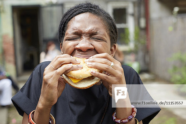 African American woman eating at backyard barbecue