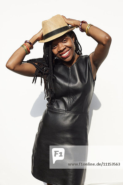 African American woman wearing leather dress and straw hat