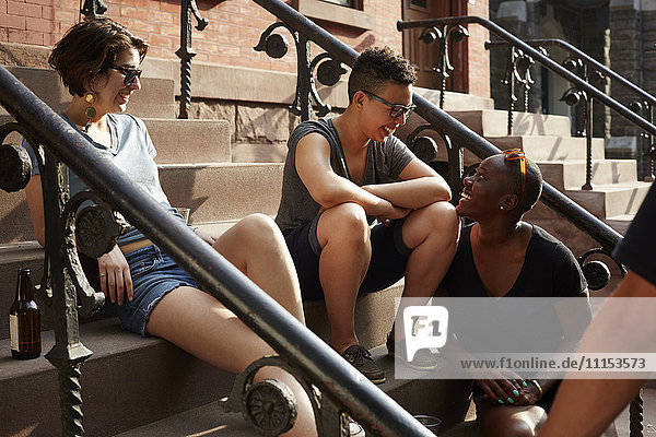 Friends relaxing on front stoop