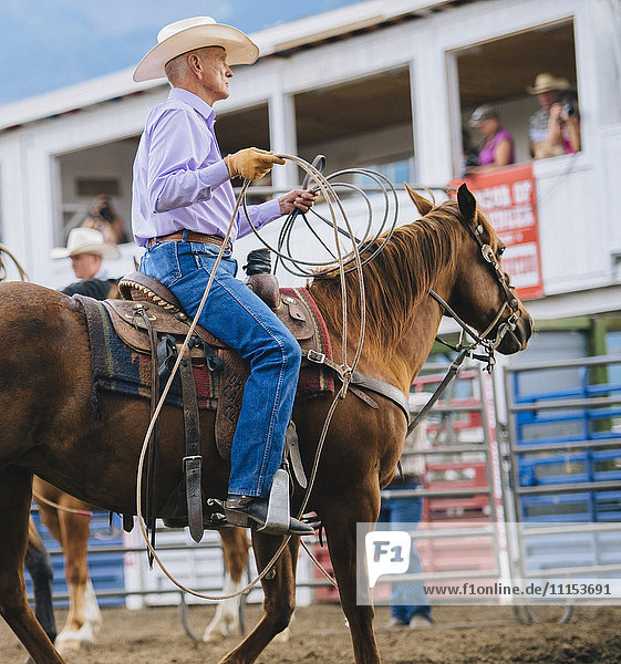 Kaukasischer Cowboy reitet Pferd beim Rodeo