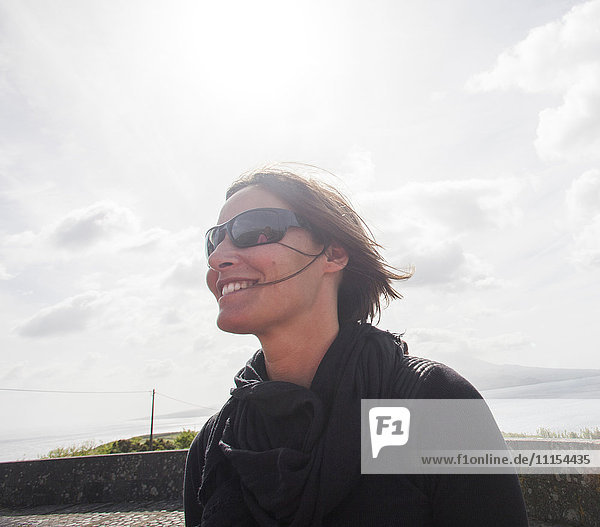 Kaukasische Frau mit Sonnenbrille und Windjacke