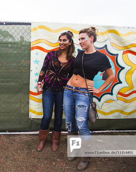 Frauen lächelnd in der Nähe von mehrfarbigen Wandmalereien