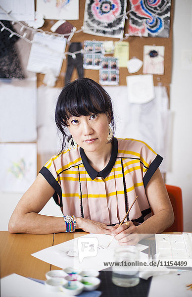 Asiatische Designerin malt im Atelier