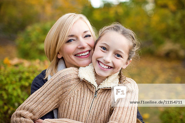 Mother and daughter hugging outdoors