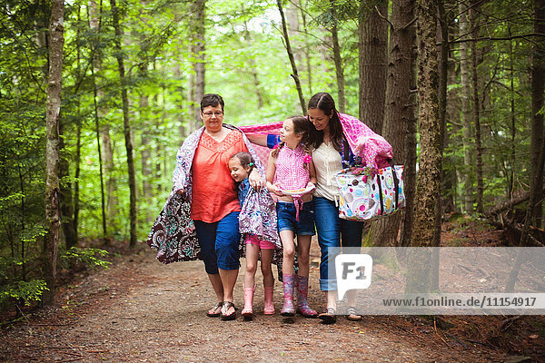 Three generations of Caucasian women walking in forest