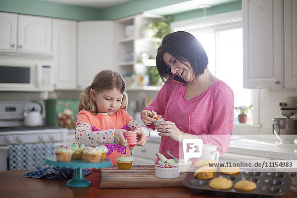 Kaukasische Mutter und Tochter backen in der Küche