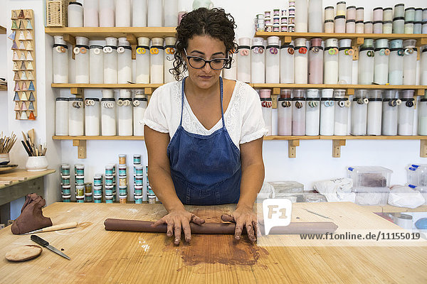 Frau bei der Arbeit mit Ton in einer Keramikwerkstatt