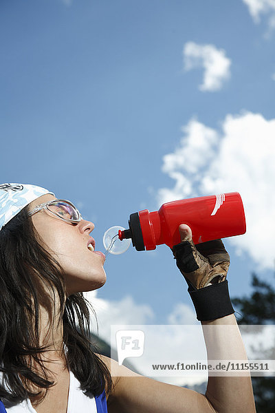Kaukasische Frau trinkt Wasserflasche im Freien