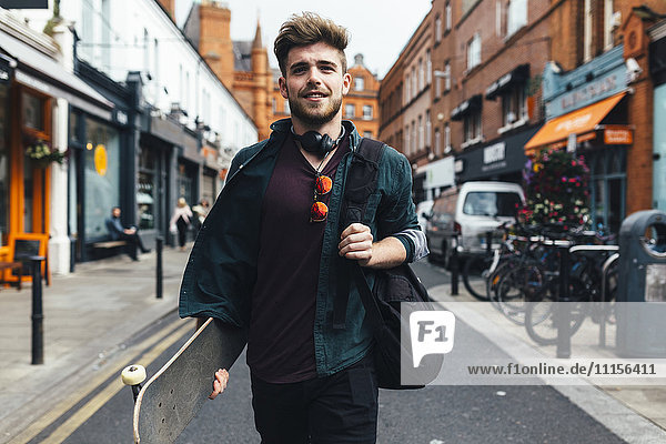 Irland  Dublin  Portrait eines jungen Mannes mit Skateboard auf der Straße
