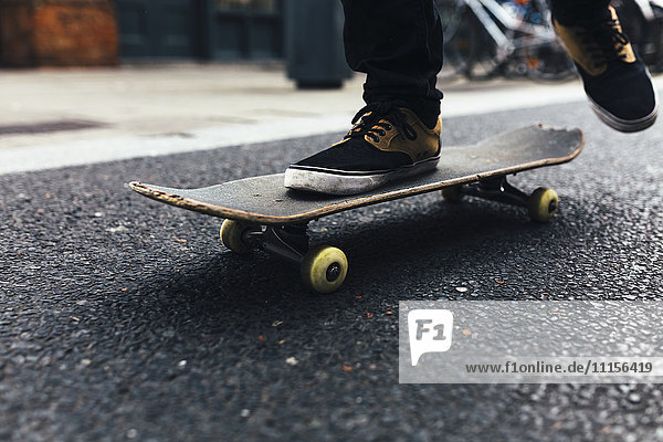 Junger Skateboarder auf der Straße  Teilansicht