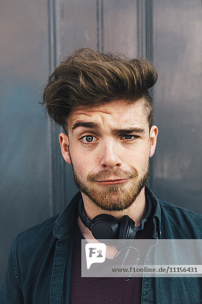 Portrait of young man with quiff pulling funny face