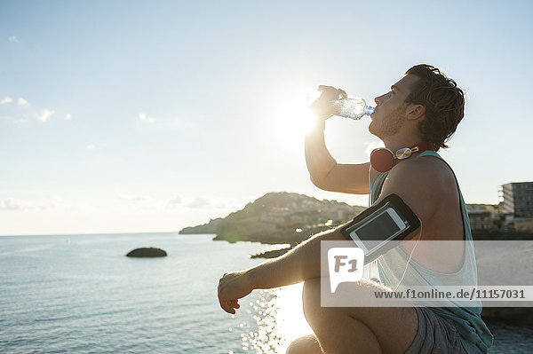 Spain  Mallorca  Jogger with water bottle against the sun
