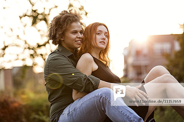 Lesbian couple in love sitting at backlight