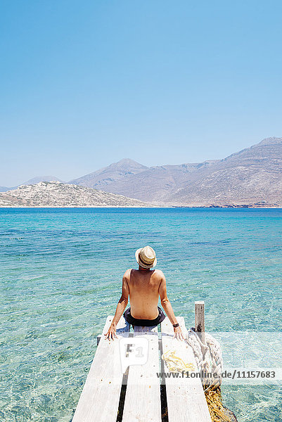 Griechenland  Kykladen  Amorgos  Mann am Rande eines hölzernen Piers  Insel Nikouria