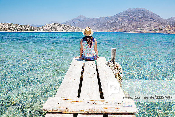 Griechenland  Kykladen  Amorgos  Frau am Rande eines hölzernen Piers  Insel Nikouria