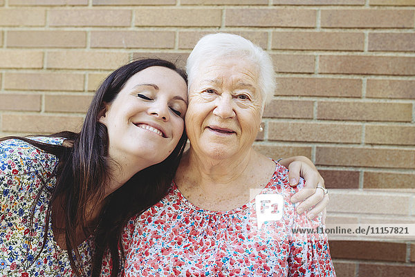 Glückliche Enkelin umarmt ihre Großmutter