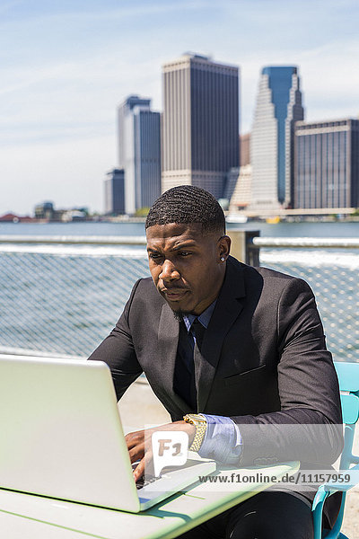 USA  Brooklyn  businessman working with laptop outdoors
