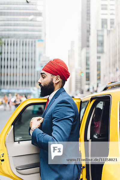 Indischer Geschäftsmann in Manhattan beim Einsteigen in ein gelbes Taxi
