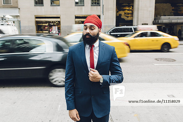 Indischer Geschäftsmann überquert Straße in Manhattan