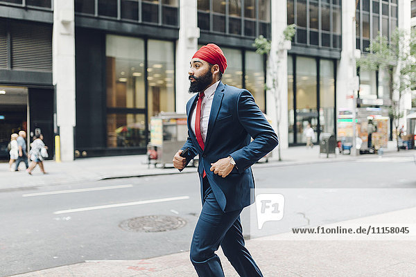 Indian businessman in Manhattan running in the street
