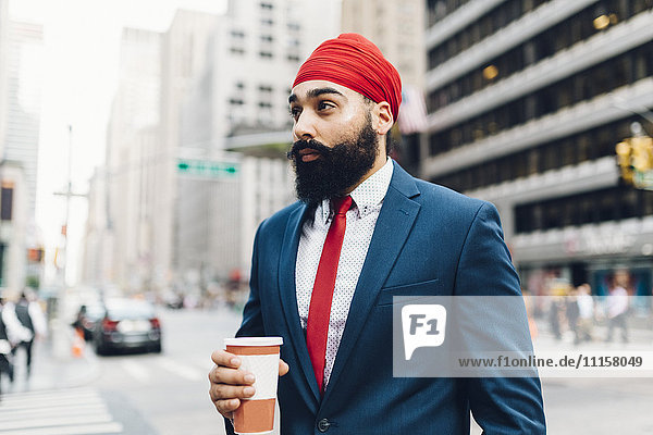 Indian businessman walking in Manhattan  drinking coffee