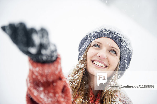 Lächelnde junge Frau bei starkem Schneefall