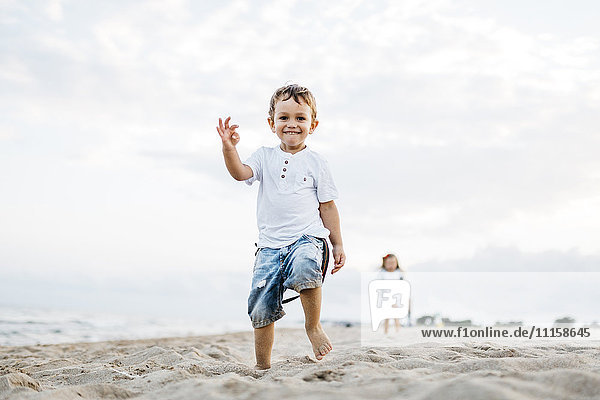 Happy little boy playing on the beach