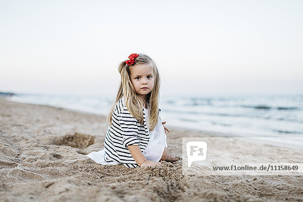 Porträt eines kleinen Mädchens  das am Strand spielt.