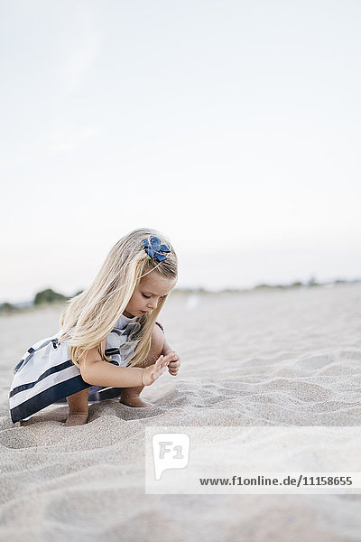 Kleines Mädchen spielt am Strand