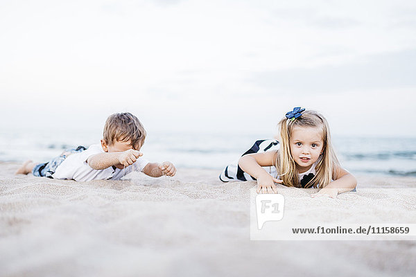 Kleiner Junge und kleines Mädchen beim Spielen am Strand