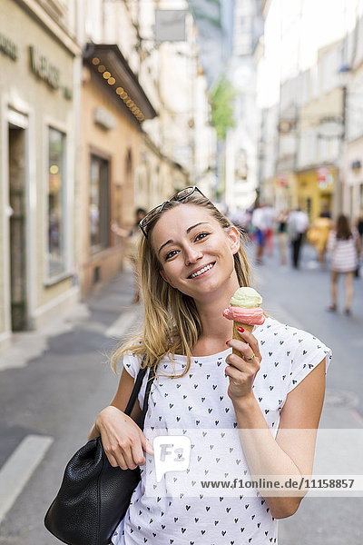 Österreich  Salzburg  lächelnde Frau auf der Einkaufsstraße mit Eistüte