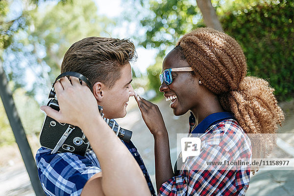 Glückliches junges Paar mit einer altmodischen Kamera im Freien