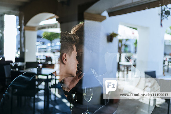 Young couple kissing in a bar seen from behind window