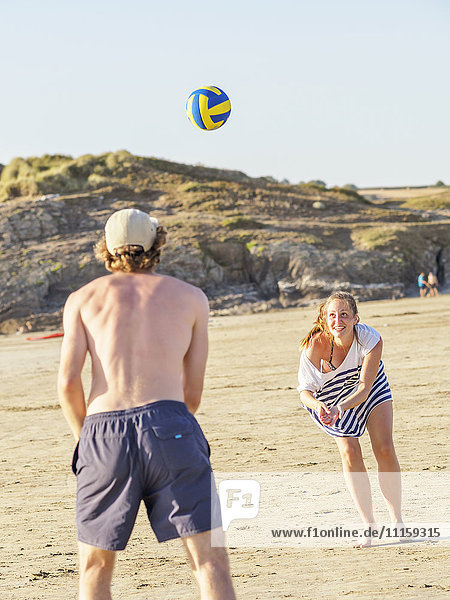 Couple at the beach playing volleyball