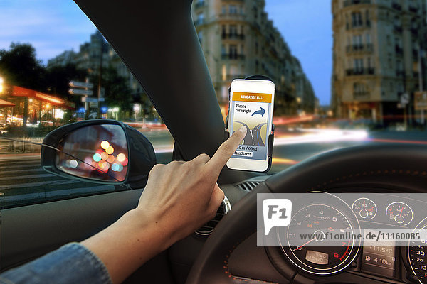 Hand mit Handy-Navigationsanwendung im Auto