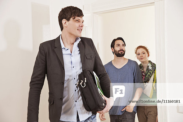 Real estate agent showing a couple around in a new apartment