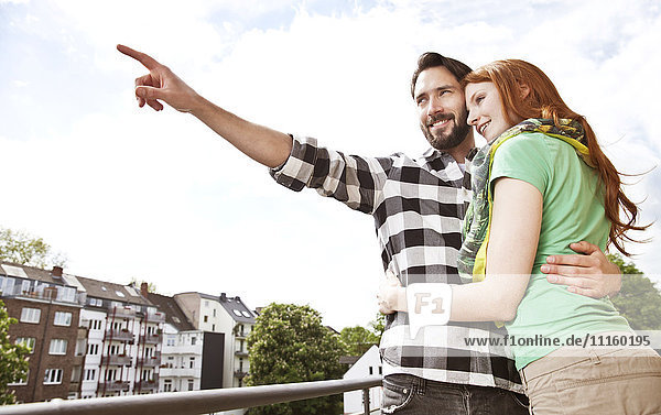 Smiling young couple hugging on balcony in the city