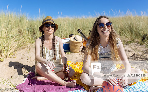 Porträt eines fröhlichen Teenagermädchens mit ihrer besten Freundin am Strand