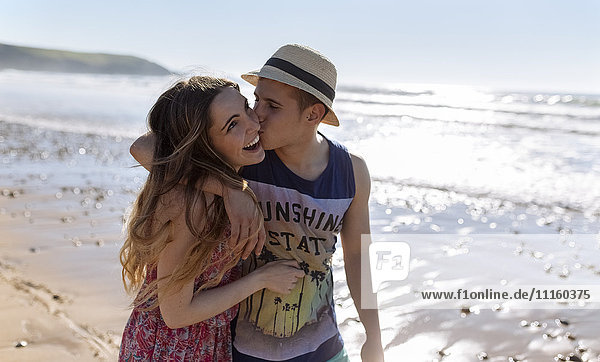 Ein glückliches junges verliebtes Paar  das am Strand spazieren geht.
