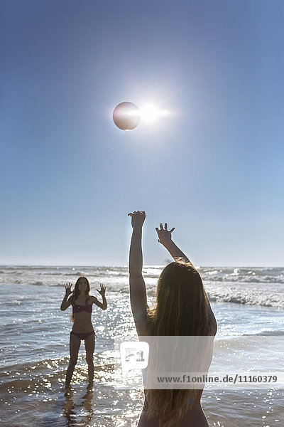 Two friends playing with ball on the beach