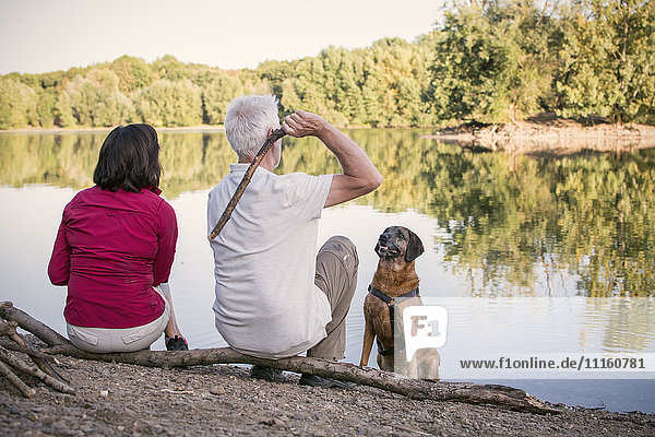 Seniorenpaar mit Hund am See