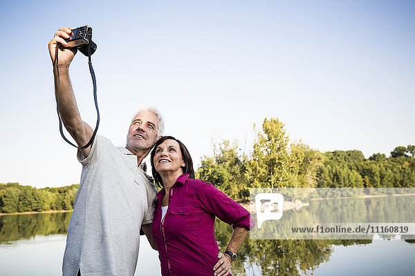 Senior couple at a lake taking a selfie