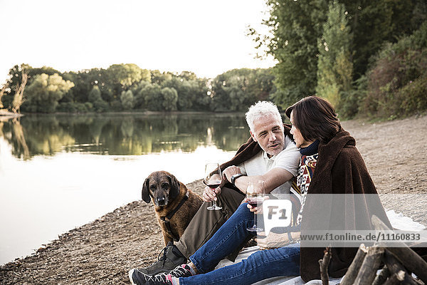 Senior couple with dog at a lake in the evening
