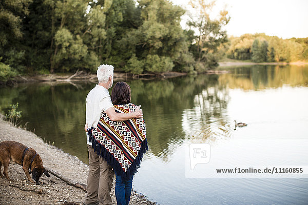 Senior couple with dog at a lake
