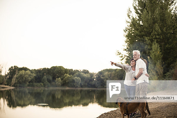 Seniorenpaar mit Hund am See