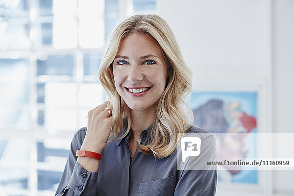 Portrait of smiling businesswoman wearing activity band