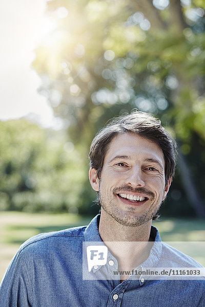 Porträt eines lächelnden Mannes im Park