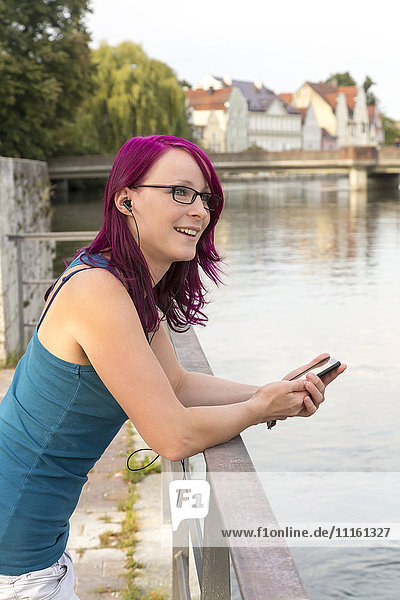 Lächelnde Frau mit gefärbten Haaren Musik hören mit Kopfhörern