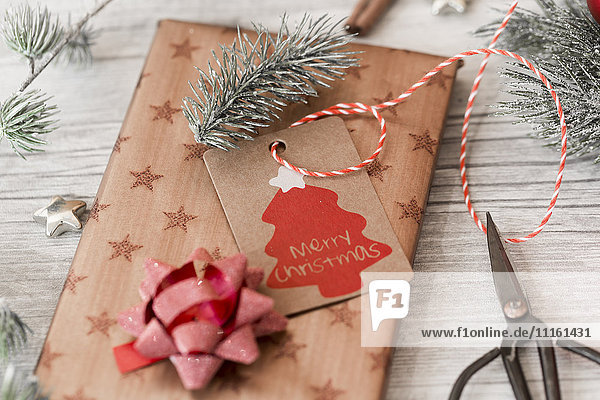 Christmas decoration scissors and wrapped presents on wood