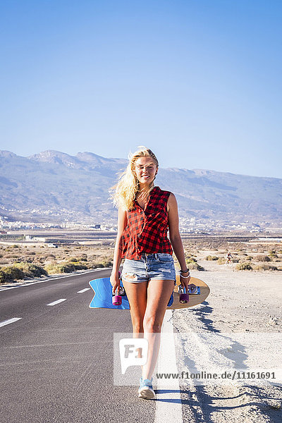 Spain  Tenerife  blond young skater walking on road